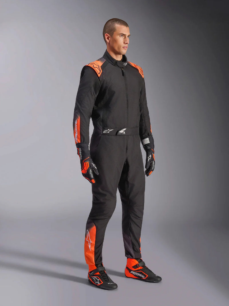Side right view of a driver wearing the Alpinestars KMX-5 V3 Kart Suit in Orange/Black color at FAST RACER