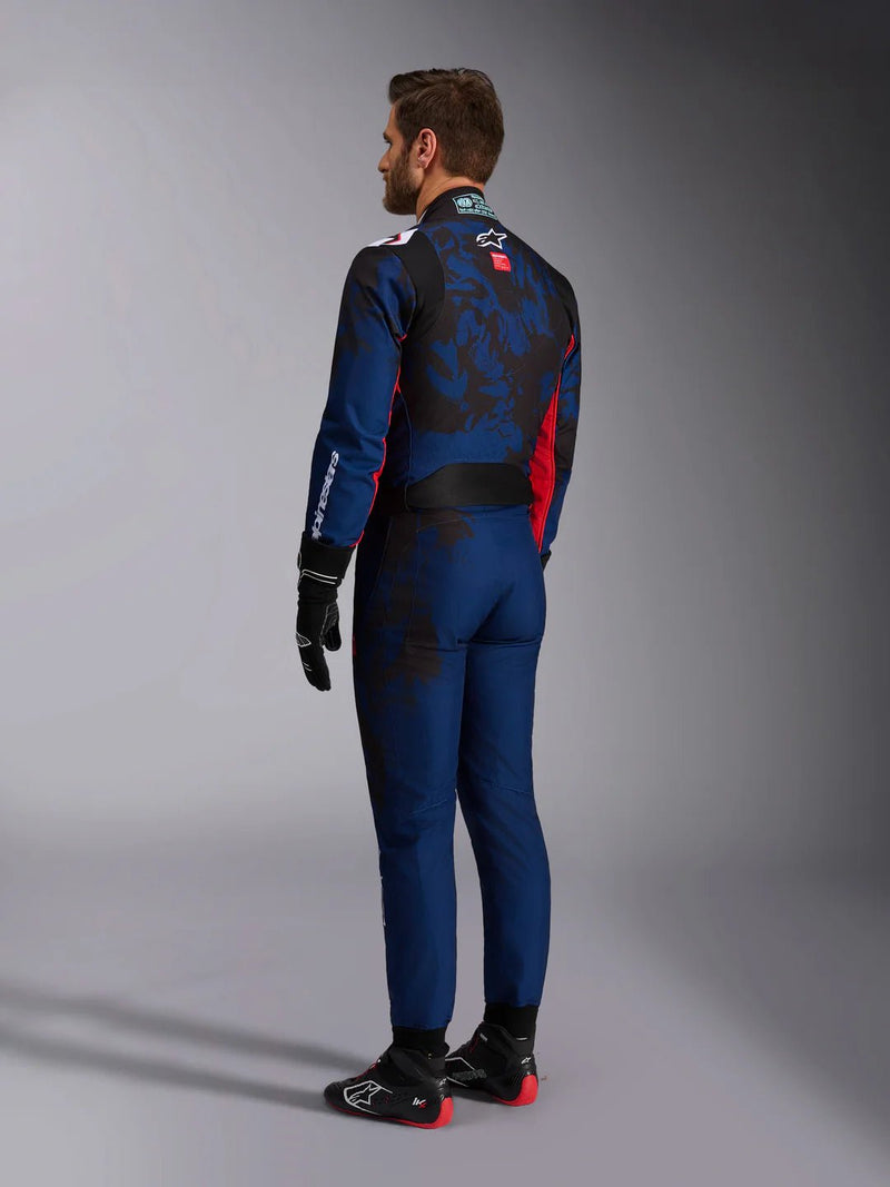 Side Back view of a driver wearing the Alpinestars KMX-9 V3 Graphic 5 Kart Suit in Navy Blue/Red color at FAST RACER