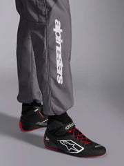 Close-up leg view of a driver wearing the Alpinestars KMX-9 V3 Graphic 5 Kart Suit in Dark Gray/Black color at FAST RACER