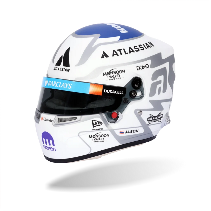 Front three-quarter view of Alex Albon’s white and blue 2026 F1 Bell mini helmet with Atlassian, Barclays, Duracell, and Kraken graphics - Fast Racer