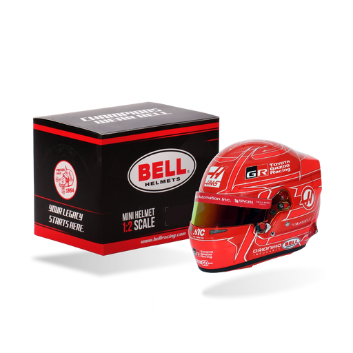 Esteban Ocon 2026 F1 Bell 1:2 scale mini helmet displayed beside its Bell presentation box in red Haas and Toyota Gazoo Racing colors - Fast Racer