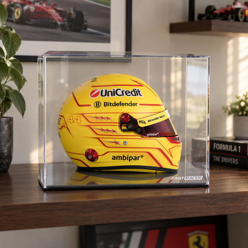 Lewis Hamilton Ferrari mini helmet in yellow livery featuring UniCredit, Bitdefender, Richard Mille, and ambipar sponsor branding with red star details and the number 44, displayed inside a clear acrylic case on a wooden shelf with a Ferrari poster and Formula 1 memorabilia in the background.