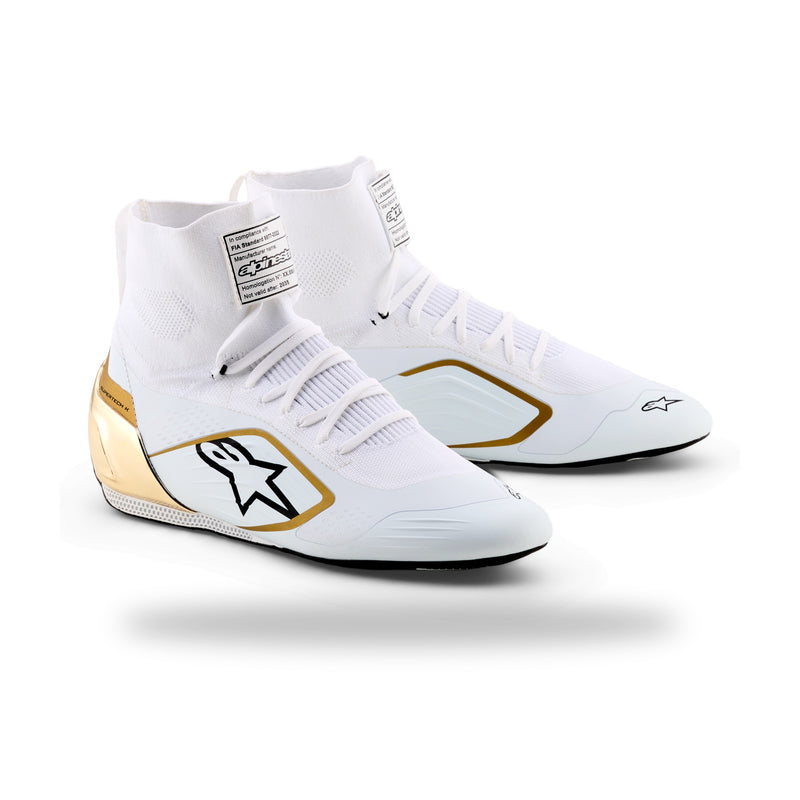 Alpinestars Supertech K karting shoe in White/Black/Gold, three-quarter view with gold heel counter and gold-bordered logo
