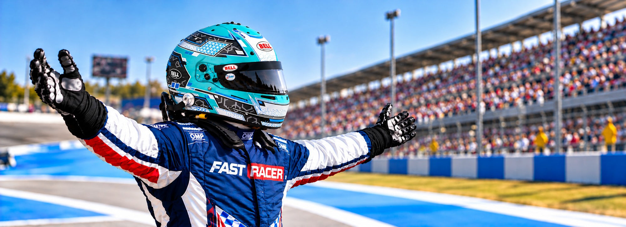 A race driver in a blue, white, and red racing suit with a Bell RS7 Stamina Racing Helmet celebrates with arms raised on a racetrack, with grandstands and a crowd in the background.